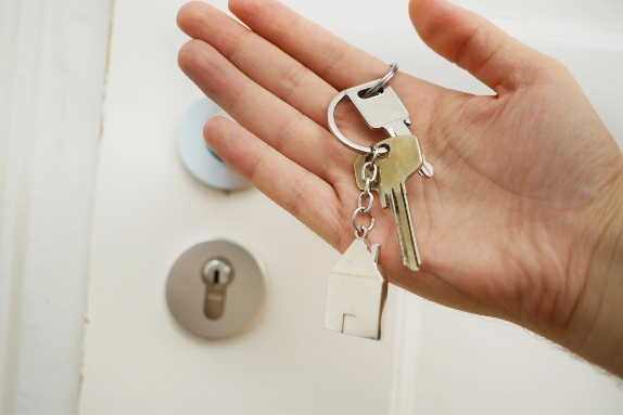 A person’s hand holding keys to their new home